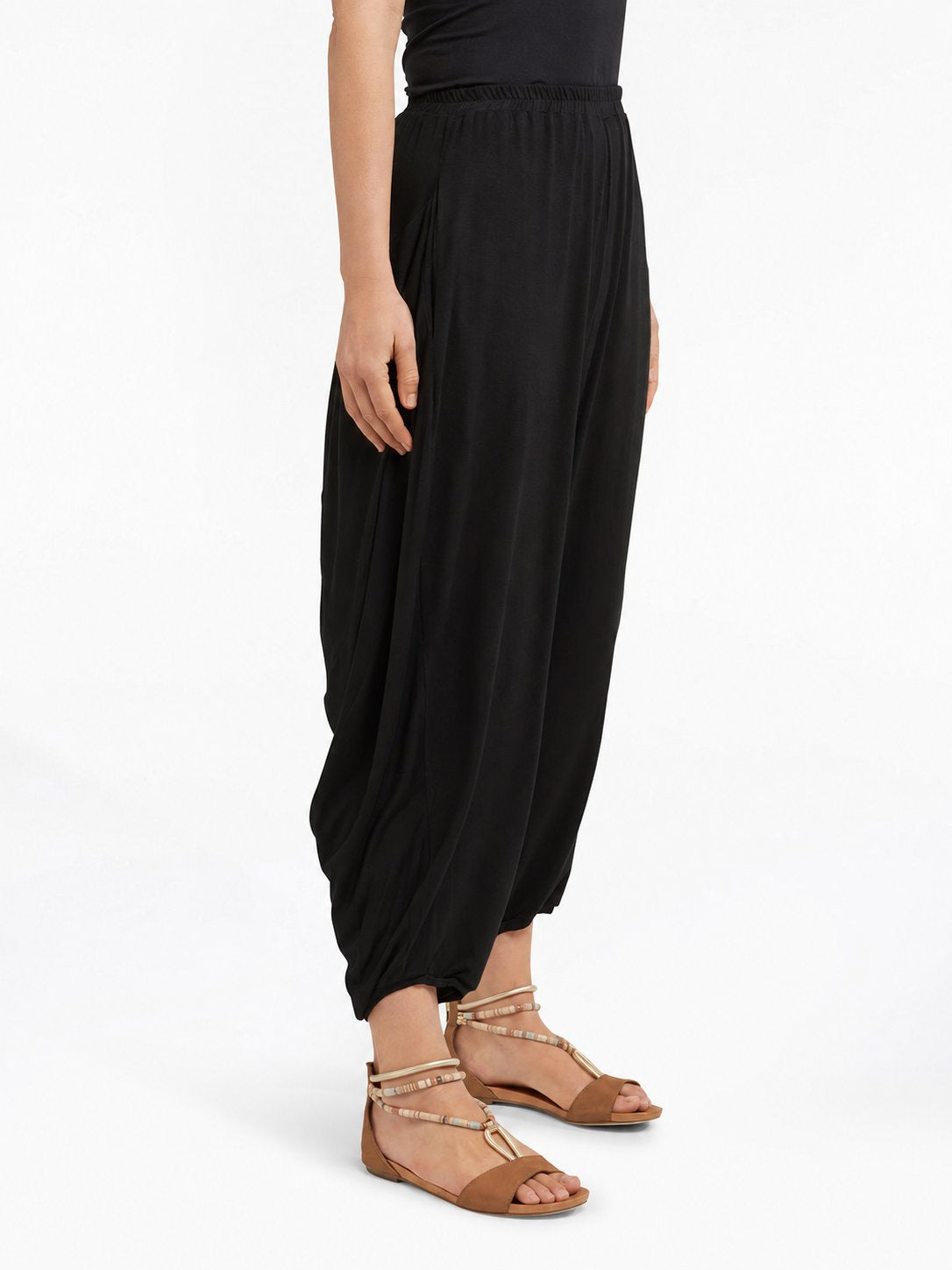 Angled side view of Black Akira Barrel Pants, showing the side drape and barrel leg shape.