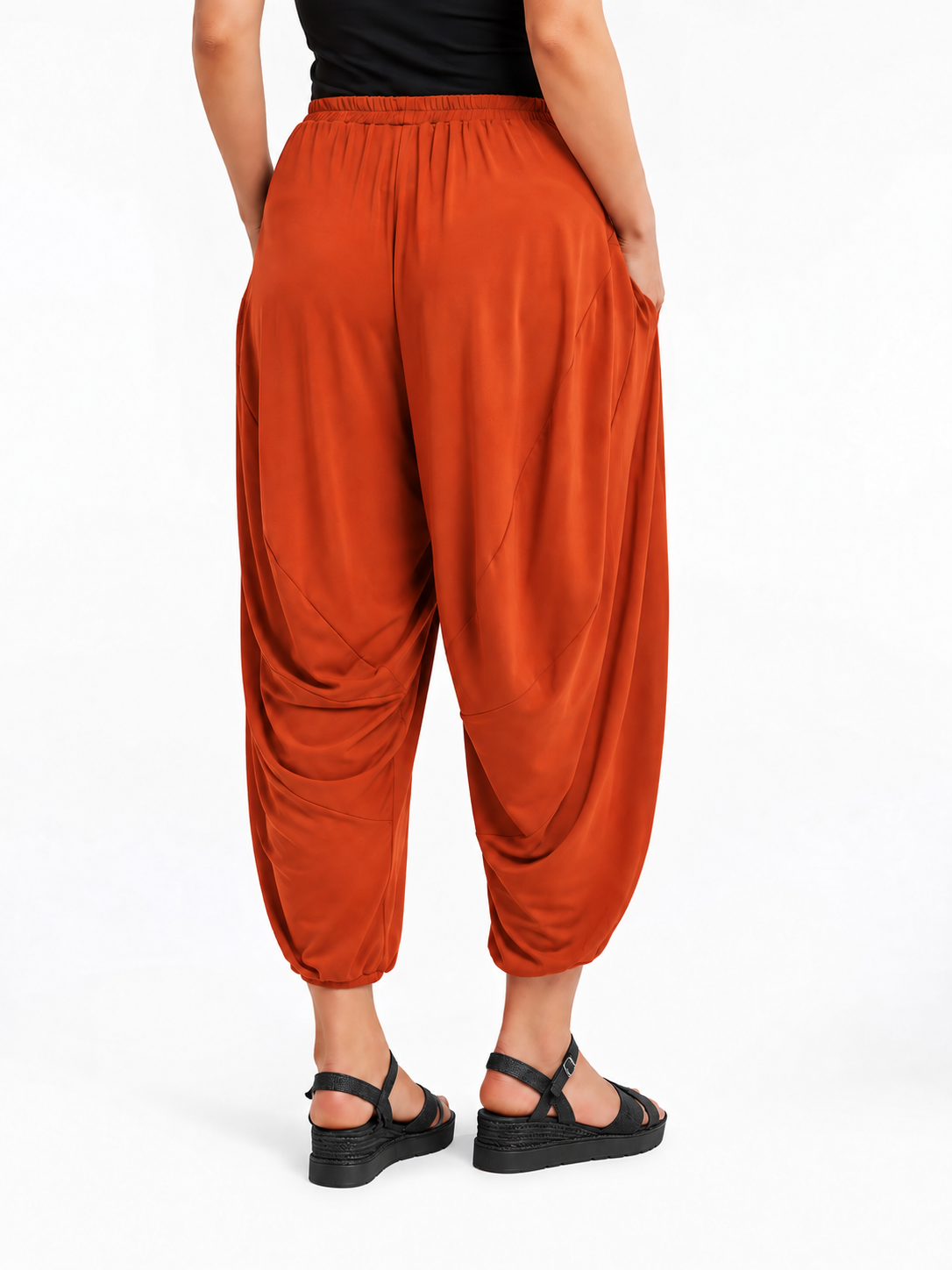 Back view of Rust Orange Akira Barrel Pants, showing the draping back panels and cropped cuffs.