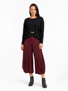 full body styled view of the Shiraz Red Marlee Wide Leg Pants styled with a relaxed top and ankle boots
